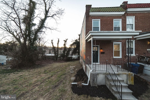 view of front of property with a tile roof and brick siding