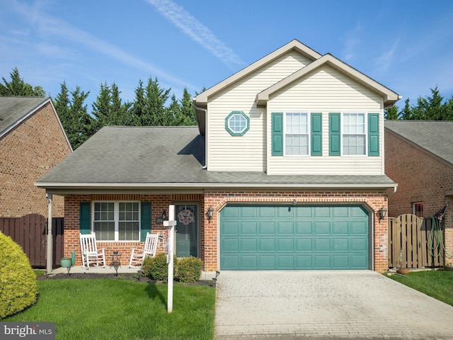 traditional-style home featuring decorative driveway, brick siding, roof with shingles, fence, and a front lawn