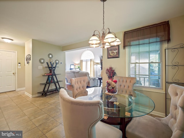 dining area with baseboards, a chandelier, and light tile patterned flooring