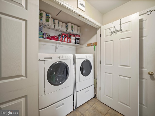 washroom with laundry area, washing machine and dryer, and light tile patterned floors