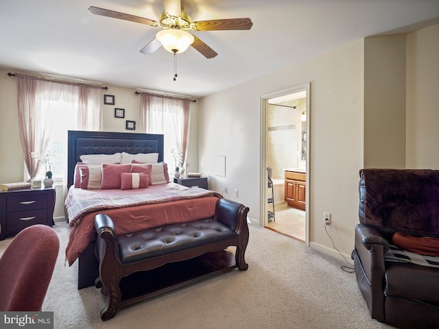 bedroom featuring baseboards, ensuite bath, a ceiling fan, and light colored carpet