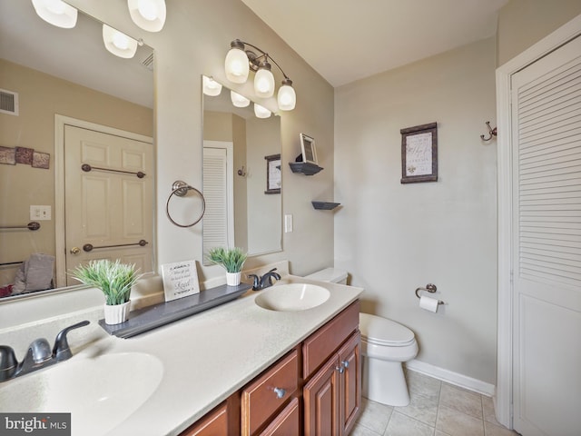 bathroom featuring a closet, tile patterned flooring, a sink, and toilet