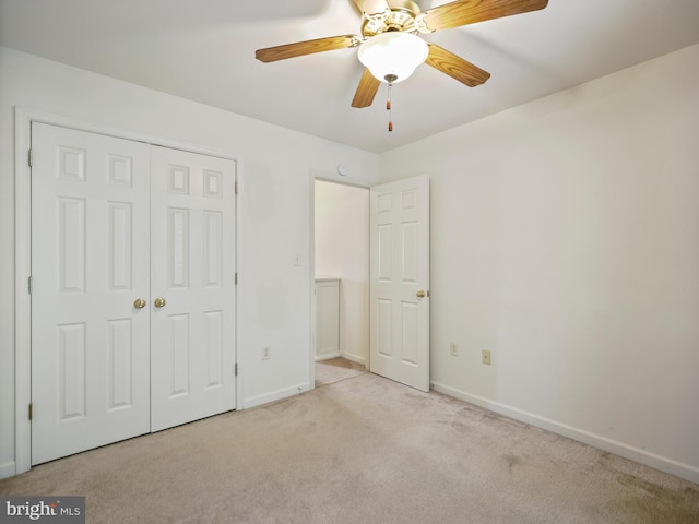 unfurnished bedroom featuring ceiling fan, a closet, carpet flooring, and baseboards