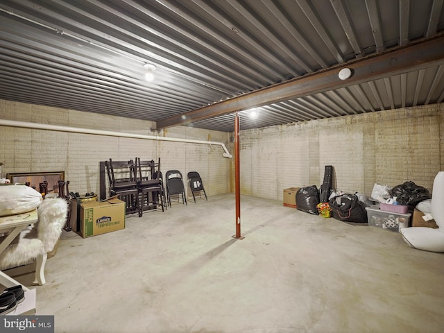 basement featuring brick wall and metal wall