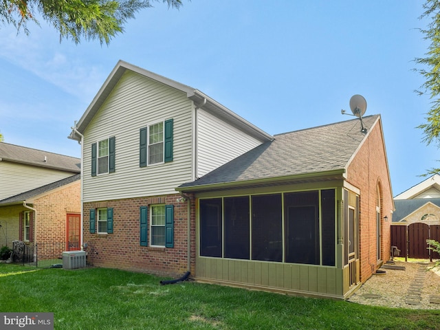 back of house featuring a sunroom, fence, cooling unit, a yard, and brick siding