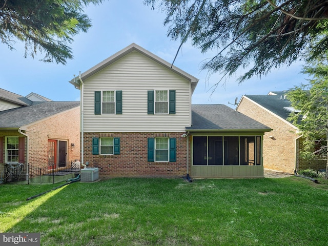 rear view of property with a shingled roof, central AC unit, a sunroom, a yard, and brick siding