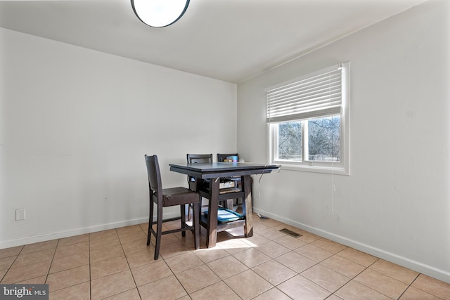 dining space featuring baseboards, visible vents, and light tile patterned flooring