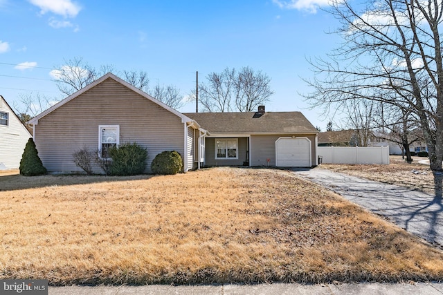 ranch-style home with concrete driveway, a chimney, an attached garage, and fence