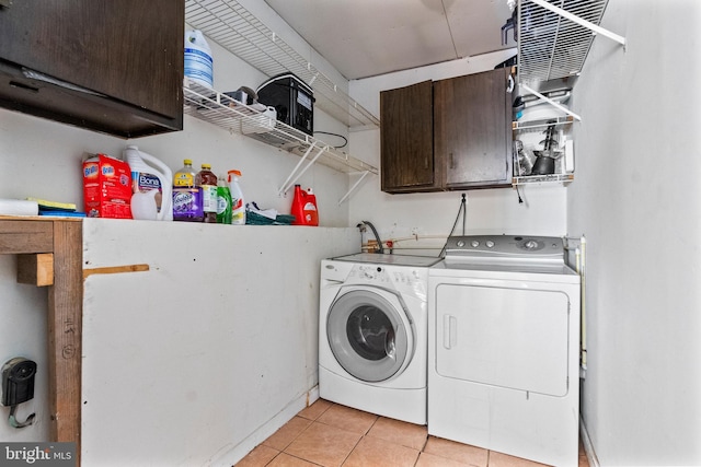 laundry room with cabinet space, washing machine and dryer, and light tile patterned floors