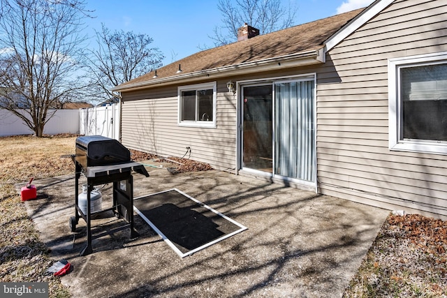 view of patio featuring a grill and fence