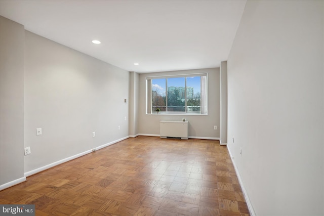 spare room featuring radiator heating unit, recessed lighting, and baseboards