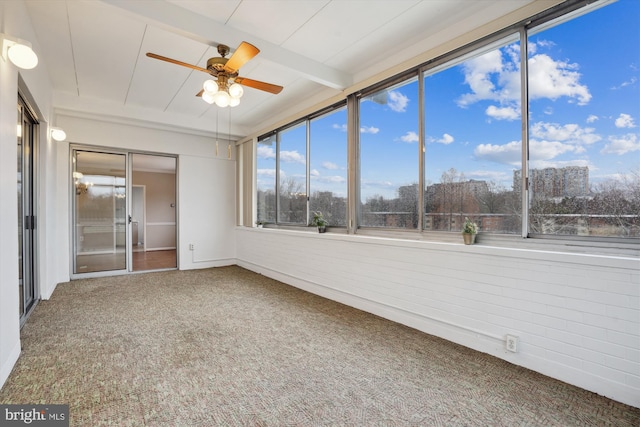 unfurnished sunroom with a ceiling fan and beam ceiling