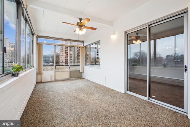 unfurnished sunroom featuring plenty of natural light, beam ceiling, and a ceiling fan