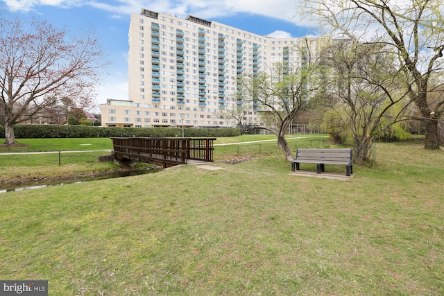 view of home's community featuring a yard and fence