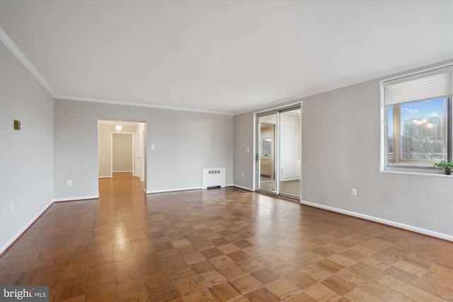 empty room featuring crown molding, radiator heating unit, and baseboards