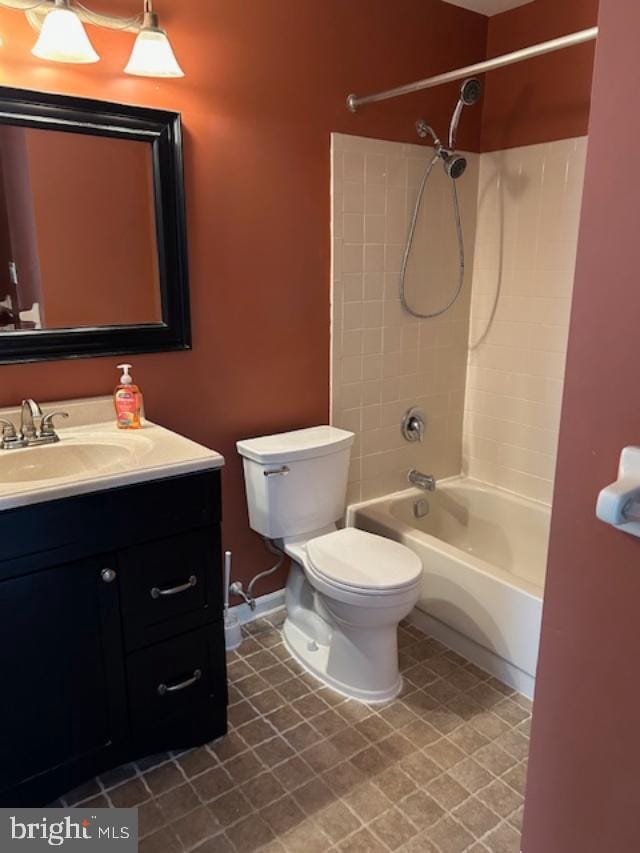 bathroom featuring toilet, baseboards,  shower combination, and vanity