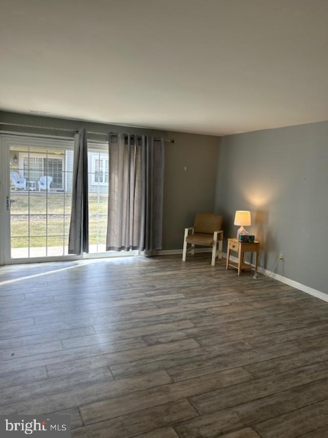 unfurnished room featuring dark wood finished floors and baseboards