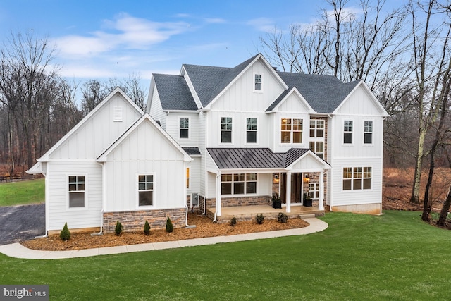 modern farmhouse style home with board and batten siding, a standing seam roof, covered porch, and roof with shingles