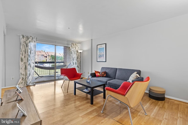 living area with baseboards and wood finished floors