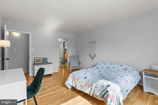 bedroom featuring a closet, light wood-type flooring, and a walk in closet