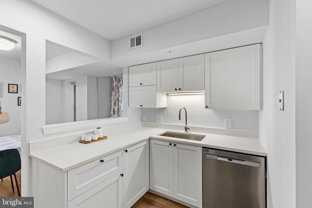 kitchen featuring a sink, visible vents, white cabinets, light countertops, and stainless steel dishwasher