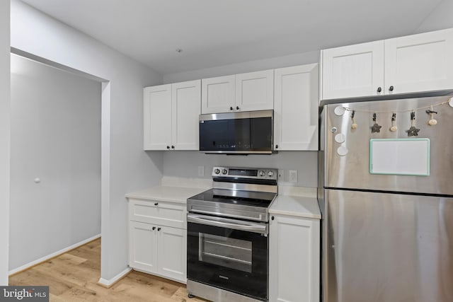 kitchen with stainless steel appliances, light wood-type flooring, white cabinets, and light countertops