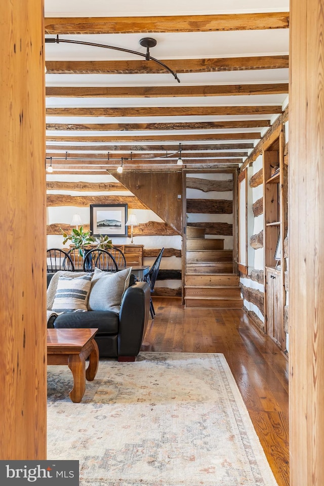 living area featuring hardwood / wood-style floors, beamed ceiling, and wood walls