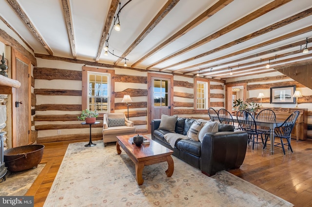 living area with rail lighting, beamed ceiling, and hardwood / wood-style flooring