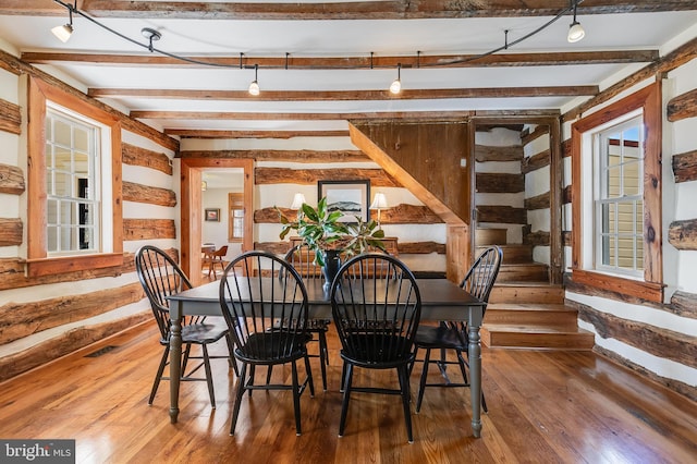 dining space featuring beam ceiling, visible vents, and hardwood / wood-style floors