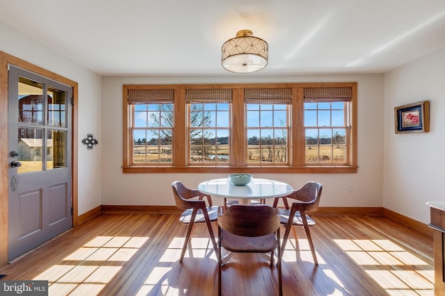 dining space featuring baseboards, a wealth of natural light, and light wood-style floors