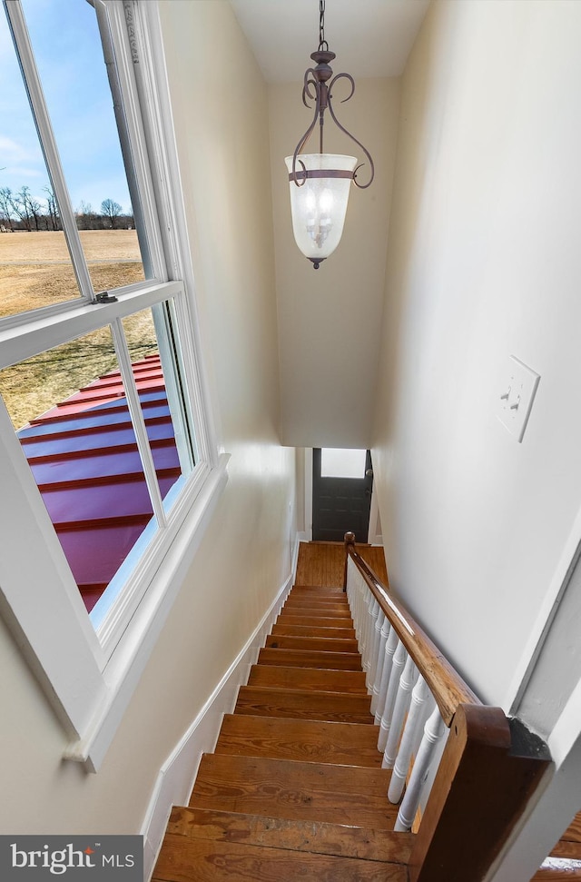 stairway featuring baseboards and wood finished floors