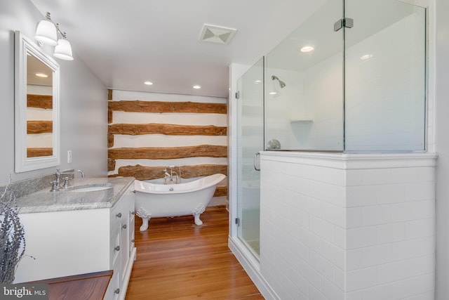 bathroom with a soaking tub, visible vents, a shower stall, vanity, and wood finished floors