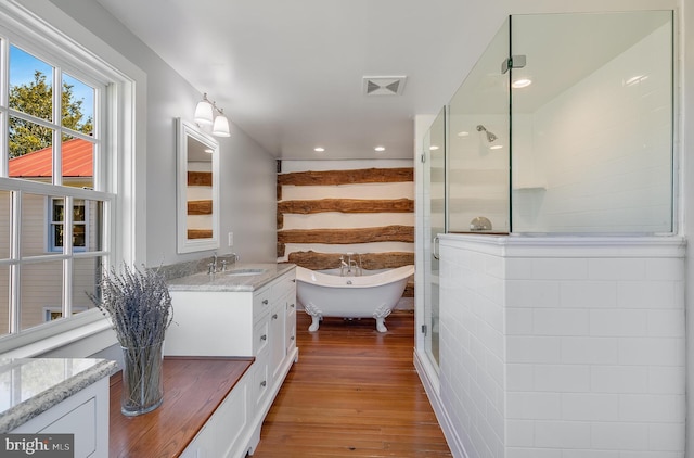 full bathroom with visible vents, tiled shower, a soaking tub, wood finished floors, and vanity