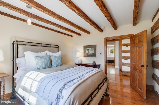 bedroom with beamed ceiling and hardwood / wood-style floors