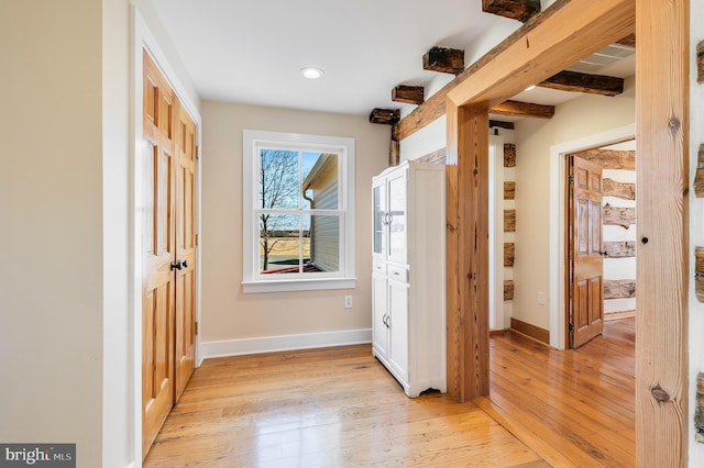 foyer entrance with recessed lighting, light wood-type flooring, beam ceiling, and baseboards