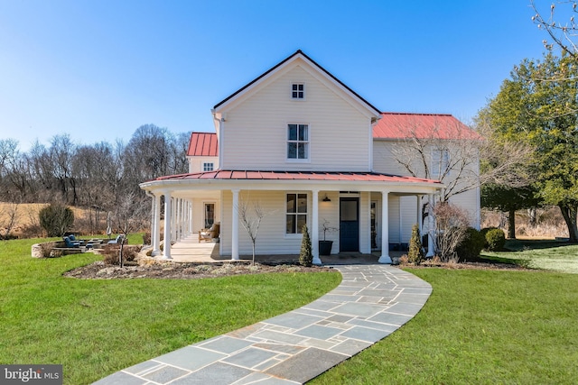 farmhouse featuring a standing seam roof, metal roof, a porch, and a front lawn