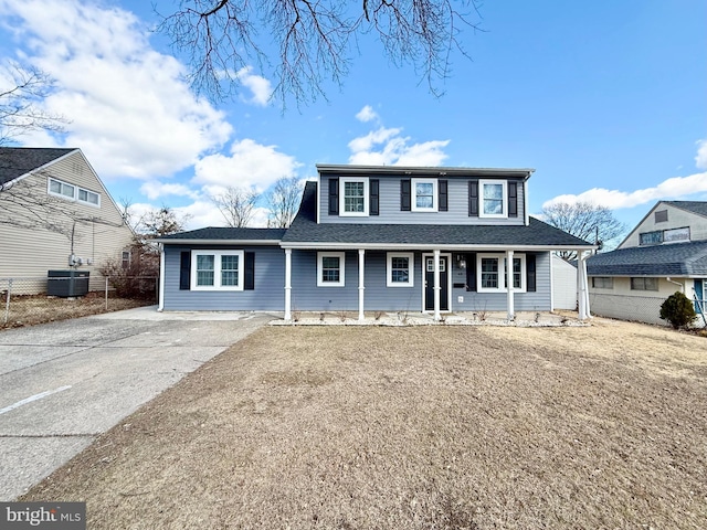 view of front of home with driveway, a porch, a shingled roof, and central air condition unit