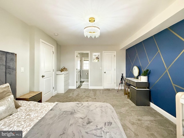 bedroom featuring a notable chandelier, an accent wall, carpet floors, and baseboards