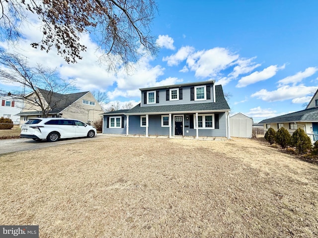 view of front of property with a shingled roof and a front lawn