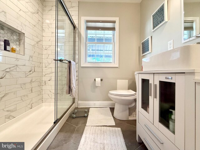 bathroom featuring a stall shower, baseboards, vanity, and toilet