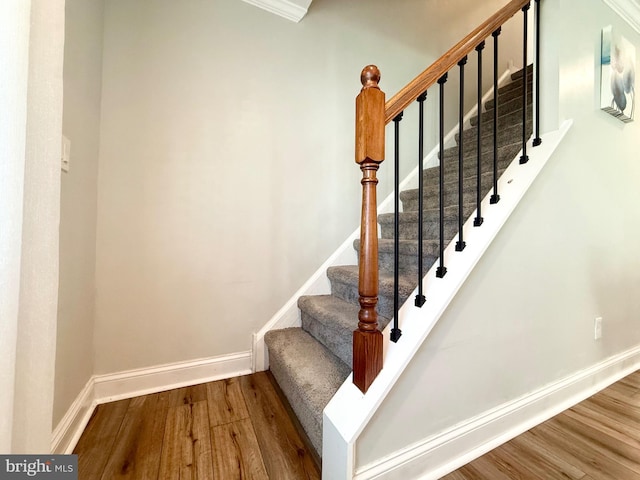 stairway with wood finished floors and baseboards