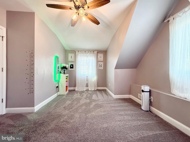 additional living space featuring lofted ceiling, carpet floors, a ceiling fan, and baseboards