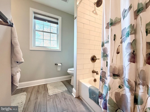 bathroom featuring shower / bath combination with curtain, baseboards, toilet, and wood finished floors