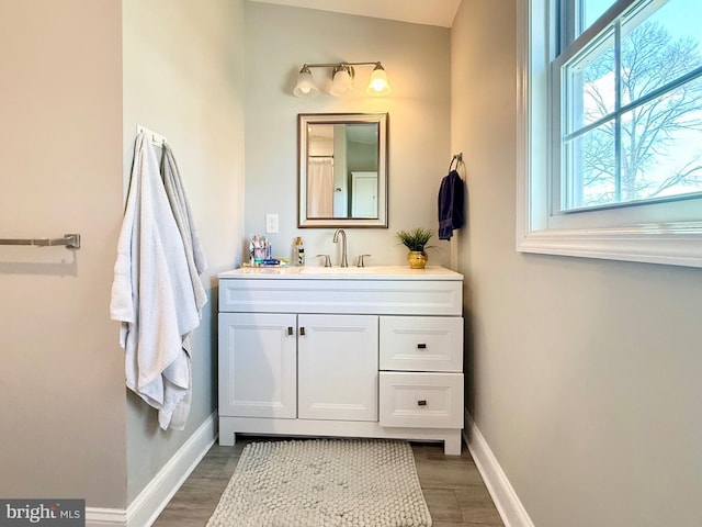 bathroom featuring vanity, baseboards, and wood finished floors