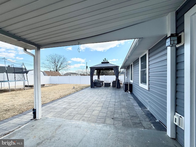 view of patio with a fenced backyard, a trampoline, and a gazebo