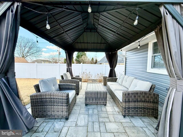 view of patio / terrace with a fenced backyard, an outdoor living space, and a gazebo