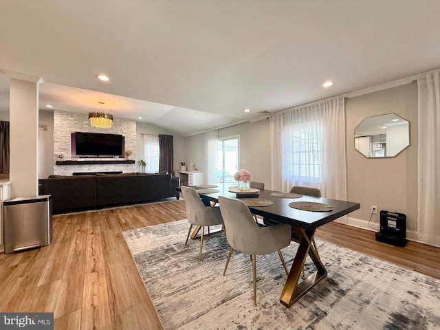 dining area with lofted ceiling, light wood finished floors, crown molding, and recessed lighting