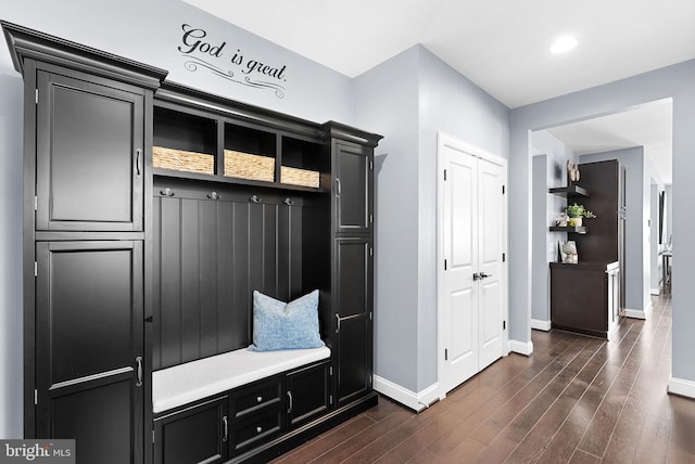 mudroom with dark wood finished floors and baseboards