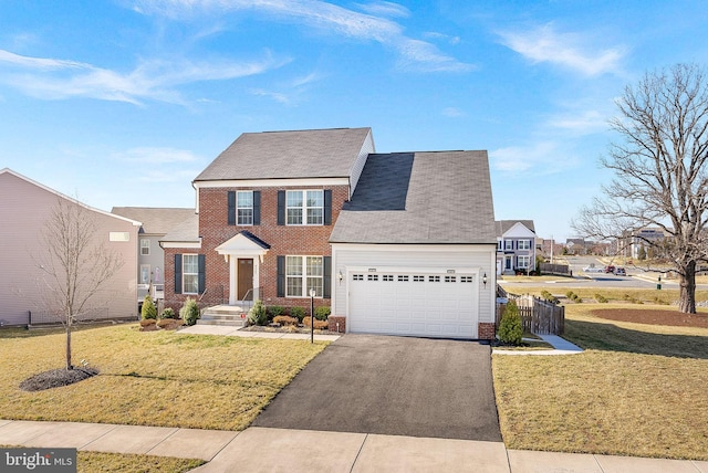 view of front facade with brick siding, fence, a front yard, a garage, and driveway