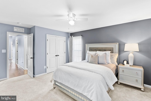 carpeted bedroom featuring visible vents, baseboards, a closet, and a ceiling fan